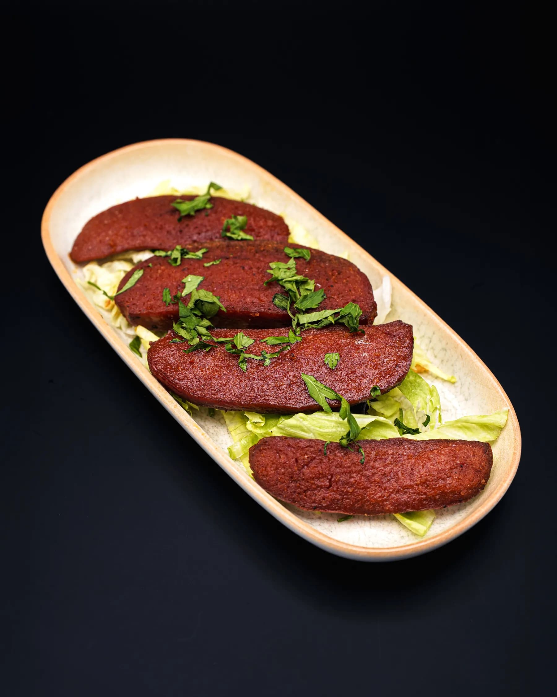Grilled slices of sucuk on an oval platter